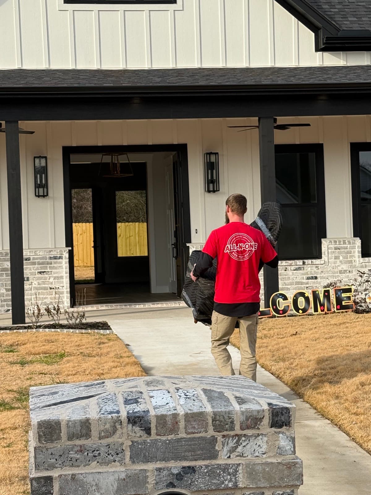 All-N-One Moving crew in red shirt at a front door job site